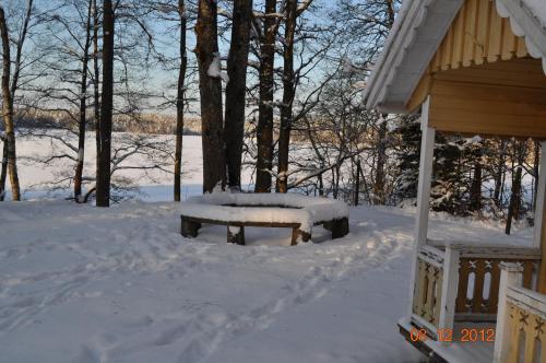 a bench covered in snow next to a house at Wismens Natur & Fiske in Krogsered