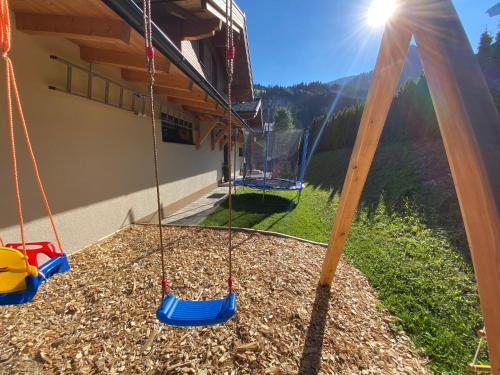 a swing set with a view of a house at Chalets AurAlpin in Kleinarl