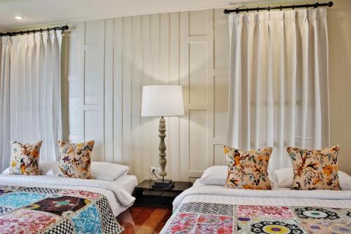 a bedroom with two beds and a lamp at Shantaa Resort, Kohkood in Ko Kood