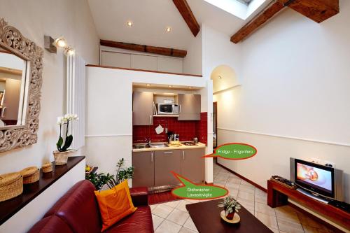 salon z kanapą i telewizorem w obiekcie The Flora and Florian Apartments - The feeling of touching the Duomo we Florencji
