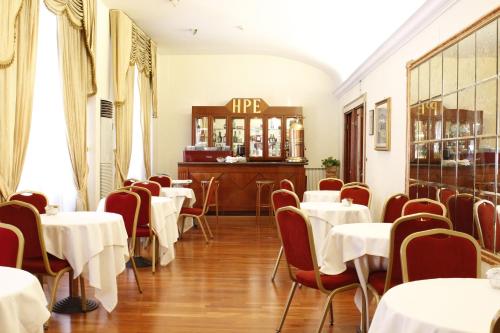restauracja ze stołami i krzesłami oraz bar w obiekcie Hotel Pace Helvezia w Rzymie