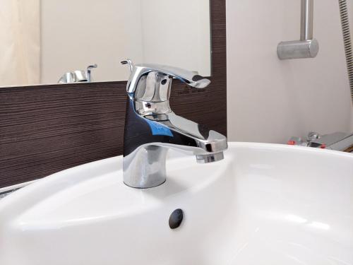 a faucet on a white sink in a bathroom at Meitetsu Inn Nagoya Sakuradori in Nagoya