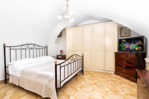 a bedroom with a bed and a dresser with a tv at Il Nido Casa Vacanze in Atrani