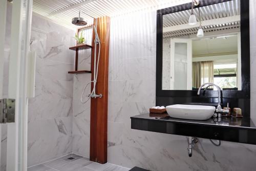 a bathroom with a sink and a mirror at Shantaa Resort, Kohkood in Ko Kood