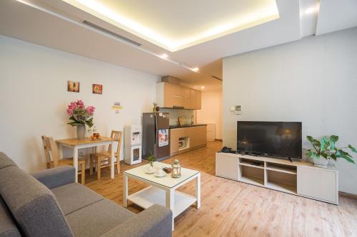 a living room with a couch and a flat screen tv at HNC Premier Hotel & Residences in Hanoi