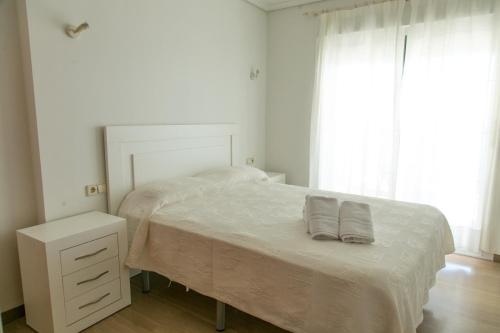 a white bedroom with a bed with two pillows on it at Sotavento Atico Calpe in Calpe