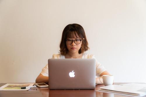 a woman sitting at a table using a laptop computer at Onsen Guesthouse HAKONE TENT in Hakone