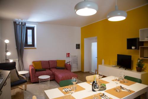 sala de estar con sofá y mesa con copas de vino en La Terrazza sul lago Lezzeno, en Lezzeno