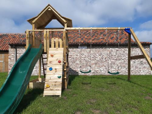 a wooden playground with a slide and swings at Hauwaertshoeve in Beernem