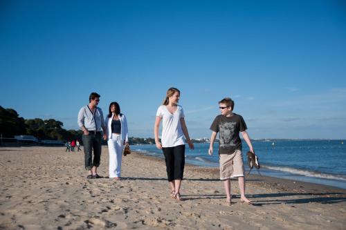 a group of people walking on the beach at Sandbanks Hotel in Poole