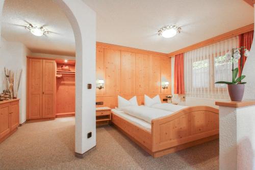 een slaapkamer met een groot bed en een bad bij Hotel Pension Hubertus in Bad Reichenhall