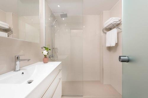 a white bathroom with a sink and a shower at Fofi’s Elegant Home in Kos Town