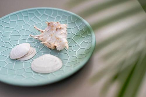 a plate with a shell and three rocks on it at Fofi’s Elegant Home in Kos Town