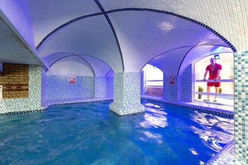a indoor swimming pool with water in a building at Hastings- Coghurst Hall park in Ore
