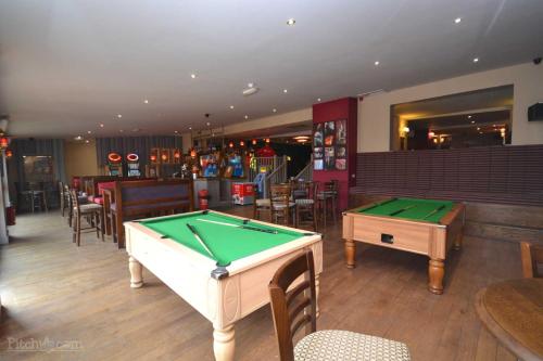 a bar with two pool tables in a room at Hastings- Coghurst Hall park in Ore
