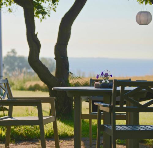 a table and chairs in front of a tree at Bakkehuset Countryhouse in Skovby