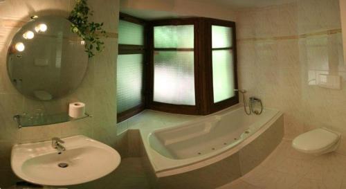 a bathroom with a sink and a tub and a toilet at Penzion Jany in Luhačovice