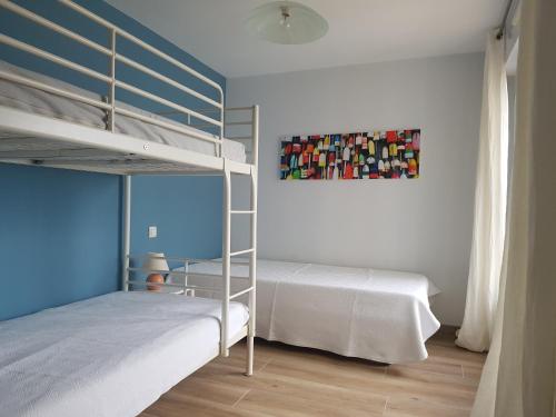 a bedroom with two bunk beds and a painting on the wall at Le Cézembre - vue 180 baie St Malo in Saint Malo