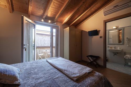 a bedroom with a bed and a window and a sink at La corte dei tre in Torre del Lago Puccini