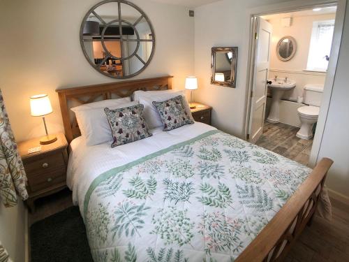 a bedroom with a large bed and a bathroom at Coedmor Cottages in Lampeter