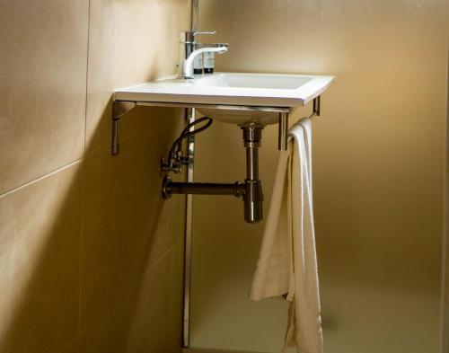 a bathroom sink with a towel hanging on the wall at Aparthotel Villas La Manga in La Manga del Mar Menor
