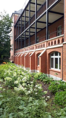 a brick building with a field of plants in front of it at Vena apartment in Wrocław