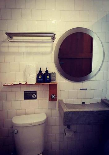 a bathroom with a toilet and a mirror at Chernchan Hostel in Chanthaburi