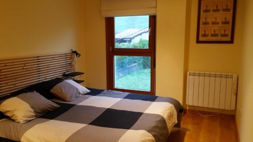 Schlafzimmer mit einem Bett und einem Fenster in der Unterkunft Apto. de Montaña La Campa en Felechosa (Aller) in Felechosa