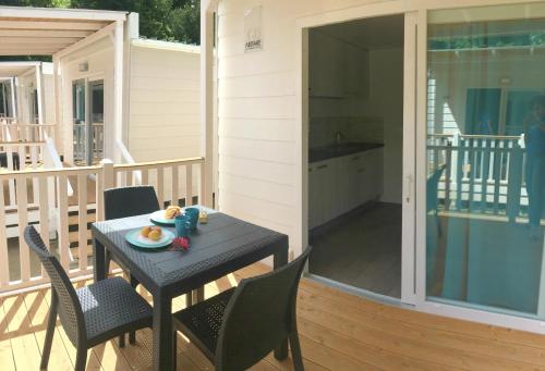 a table and chairs on a porch with a kitchen at Camping Serenissima in Malcontenta