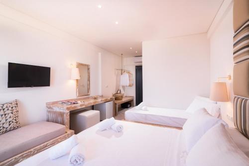 a hotel room with two beds and a television at Acron Suites in Limenaria