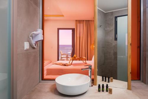 a bathroom with a tub and a bedroom with a bed at Acron Suites in Limenaria