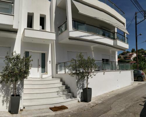 a white building with stairs and a balcony at Nea Stira Studios Kondilia in Nea Stira