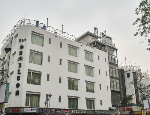 um edifício branco com muitas janelas em The Samilton em Calcutá