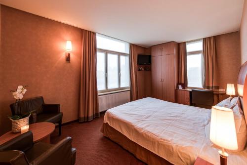 博爾納姆的住宿－Hotel De Notelaer，配有一张床和一把椅子的酒店客房