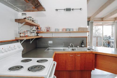 una cucina con piano cottura e lavandino di The PC Cottage a Port Campbell