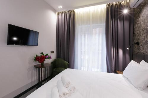 a bedroom with a white bed and a window at Kulikovskiy hotel in Kharkiv