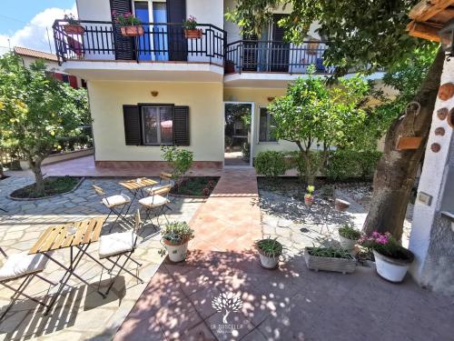 un cortile di una casa con sedie e piante di La Suscella Bed & Breakfast a Torchiara