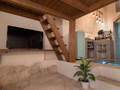 uma sala de estar com uma televisão de ecrã plano na parede em Ariad Collection em Ostuni