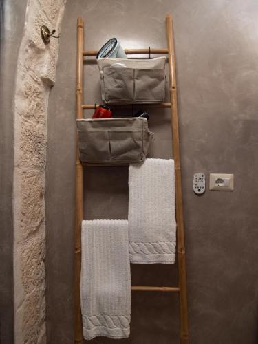 a wooden towel rack with towels on a wall at Ariad Collection in Ostuni