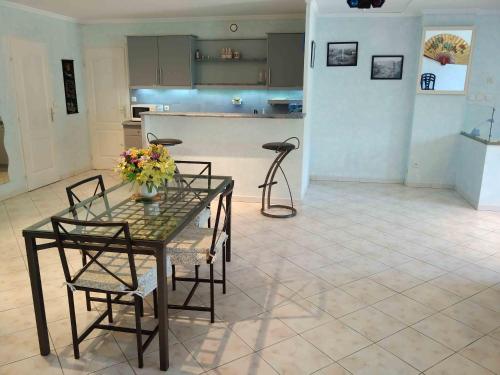 a dining room with a table and chairs and a kitchen at Pied à Terre Marseille 11° in Marseille