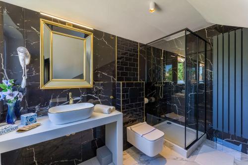 a bathroom with a sink and a shower and a toilet at Złota Regalinda & Spa in Międzyzdroje