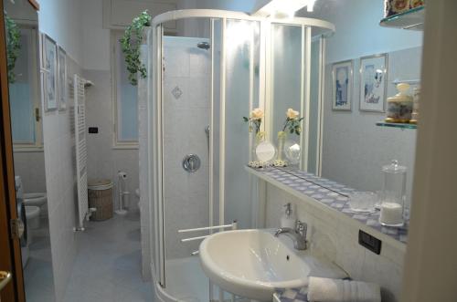 a white bathroom with a shower and a sink at B&B Villa Olmo in Como