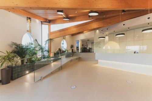a lobby of a building with a staircase and wooden ceilings at Hotel Pradillo Conil in Conil de la Frontera