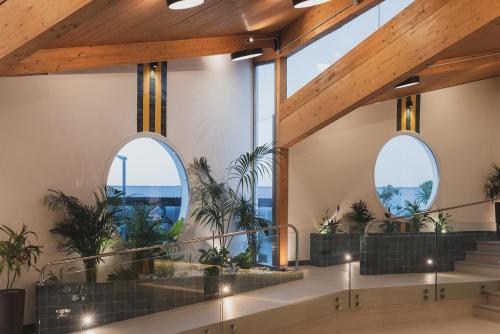 eine Lobby mit großen Fenstern und Topfpflanzen in der Unterkunft Hotel Pradillo Conil in Conil de la Frontera