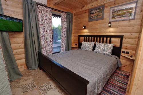 a bedroom with a bed in a log cabin at Псковские дали in Pushkinskiye Gory
