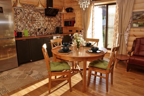 a kitchen and dining room with a wooden table and chairs at Псковские дали in Pushkinskiye Gory