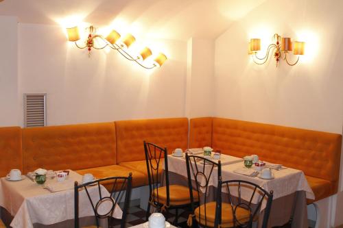 a dining room with two tables and a bench at Boutique Hotel Trevi in Rome