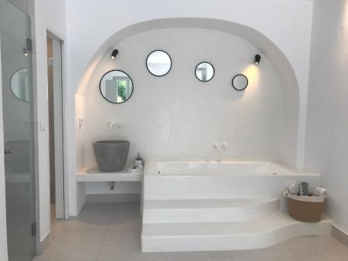 a white bathroom with a tub and two mirrors at Quartano Luxury Cycladic Residence, Adults Only (13+) in Naousa