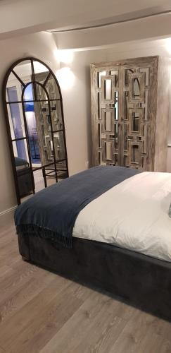 une chambre avec un grand lit et une grande fenêtre dans l'établissement La cachette, à Berre-des-Alpes