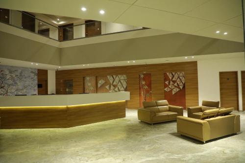 a lobby with two chairs and a reception desk at VITS The Somnath Gateway in Somnath